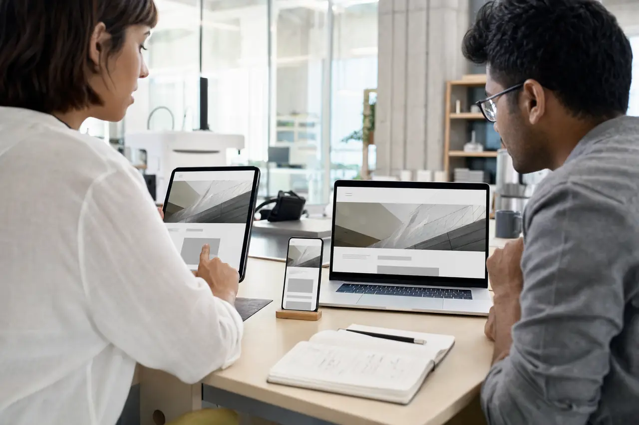 A product team reviewing an installable web app across phone, tablet, and laptop